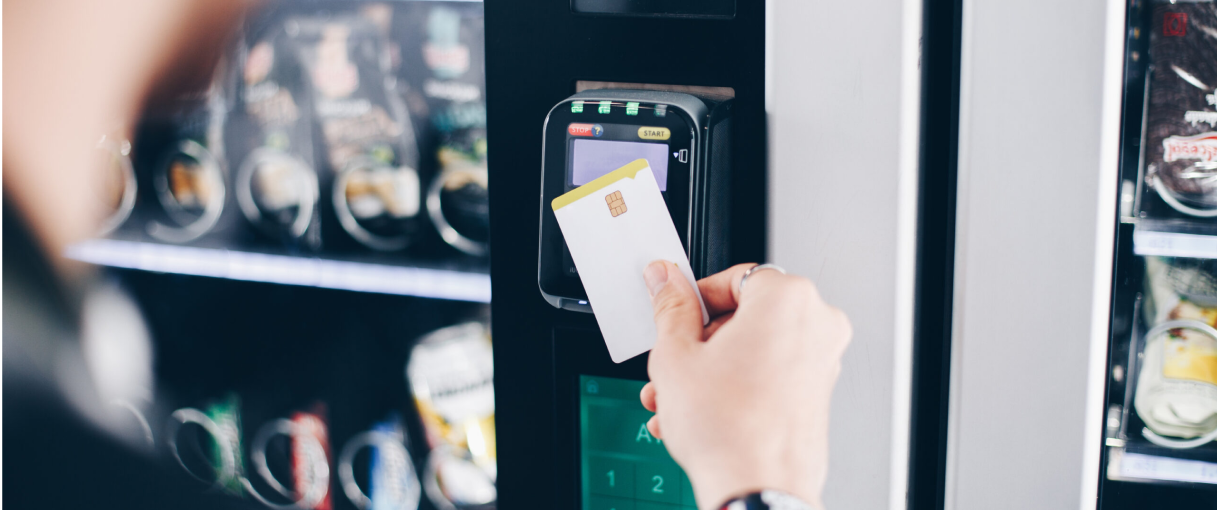 Persona pagando con tarjeta de crédito en máquina de vending